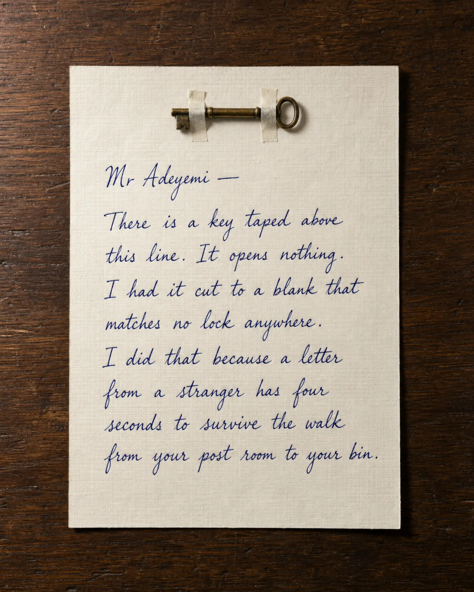A brass key taped to the head of a handwritten letter.