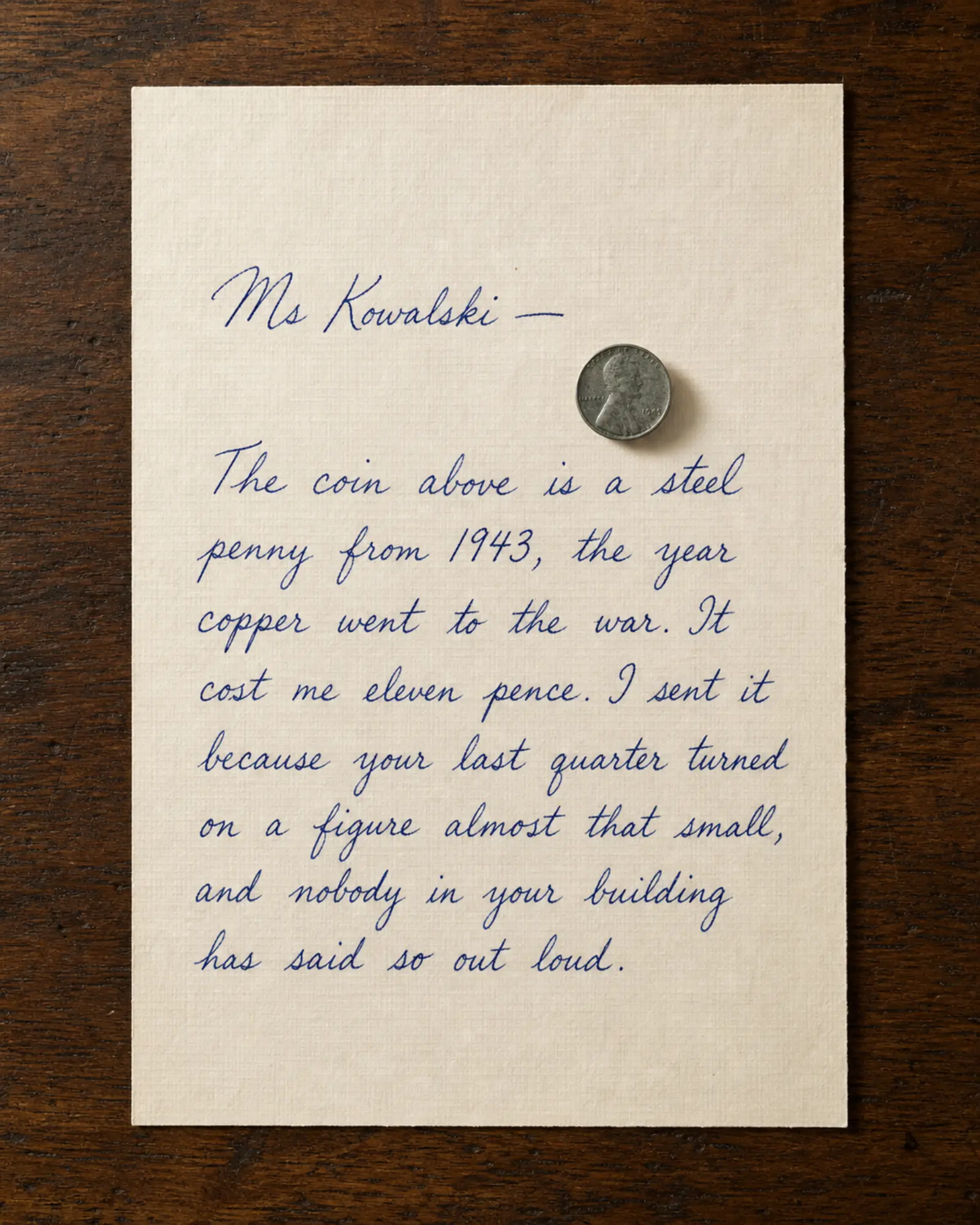 A steel penny resting on a handwritten letter.