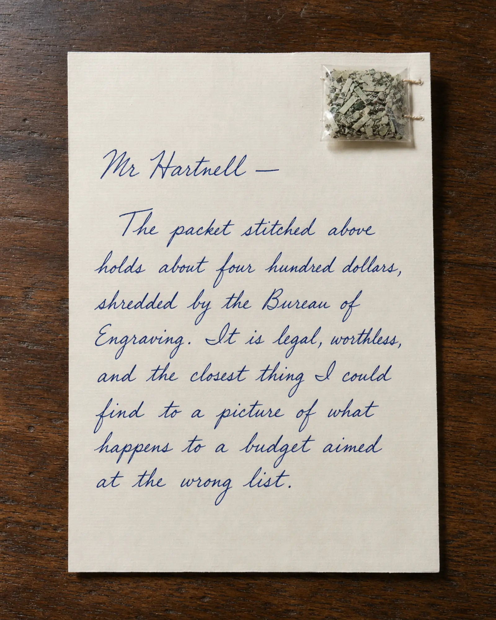 A sachet of shredded banknotes stitched to a handwritten letter.