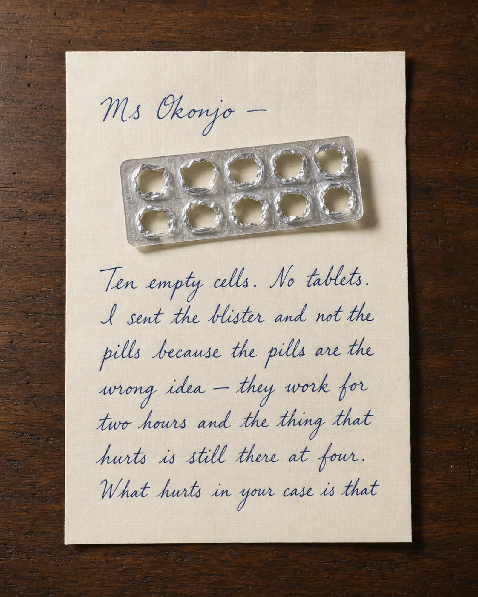 An empty blister pack lying across a handwritten letter.