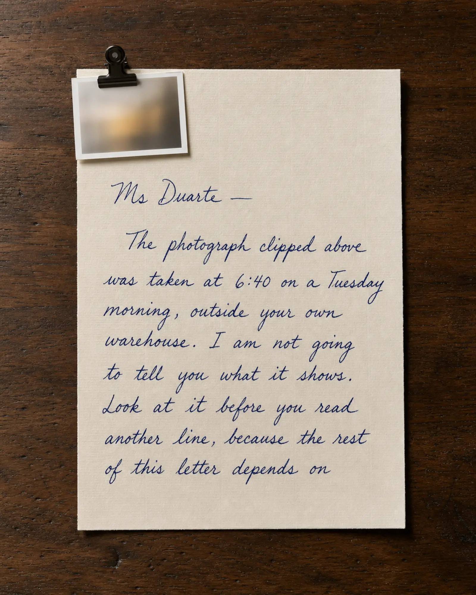 A photograph clipped to the corner of a handwritten letter.