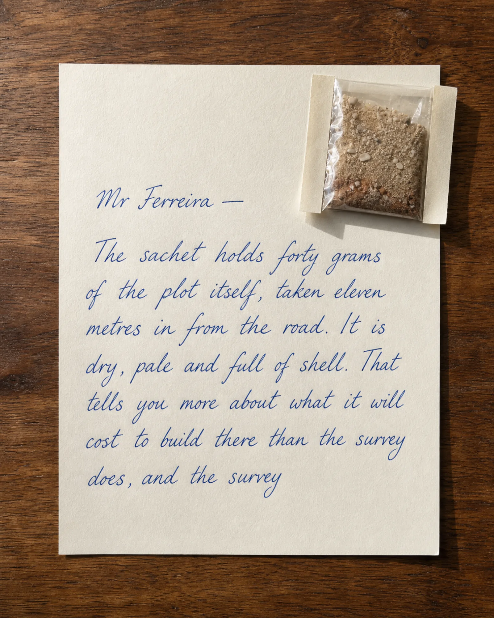 A sealed sachet of soil taped to a handwritten letter.