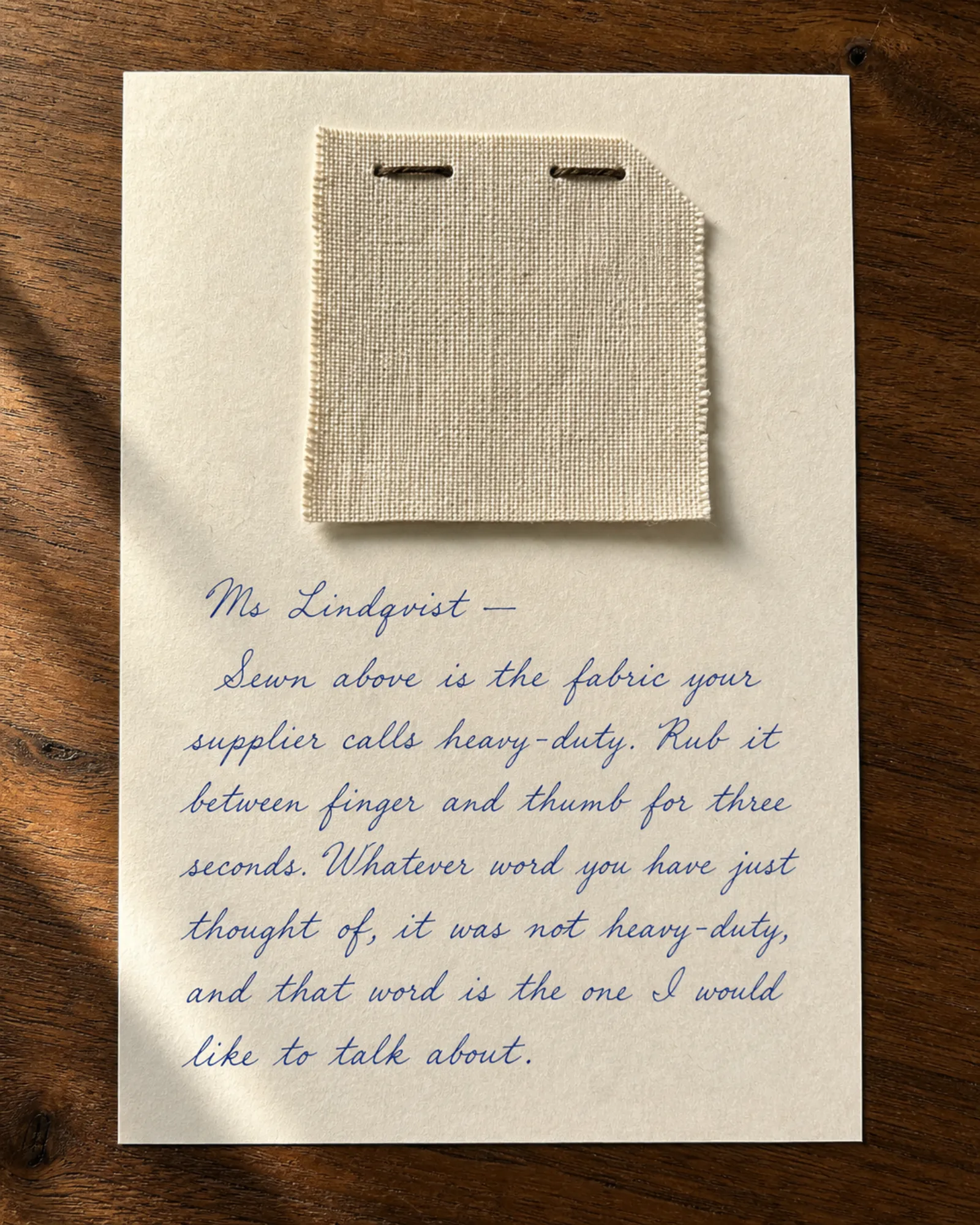 A fabric swatch stitched to a handwritten letter.