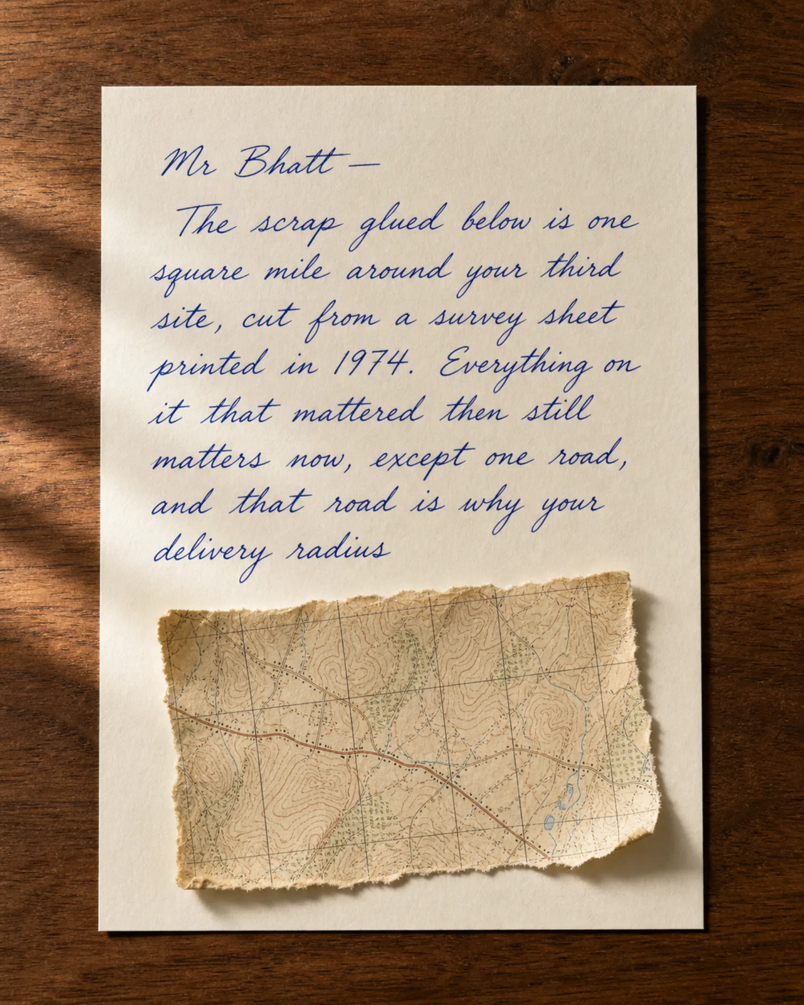 A torn fragment of an old survey map glued to a handwritten letter.