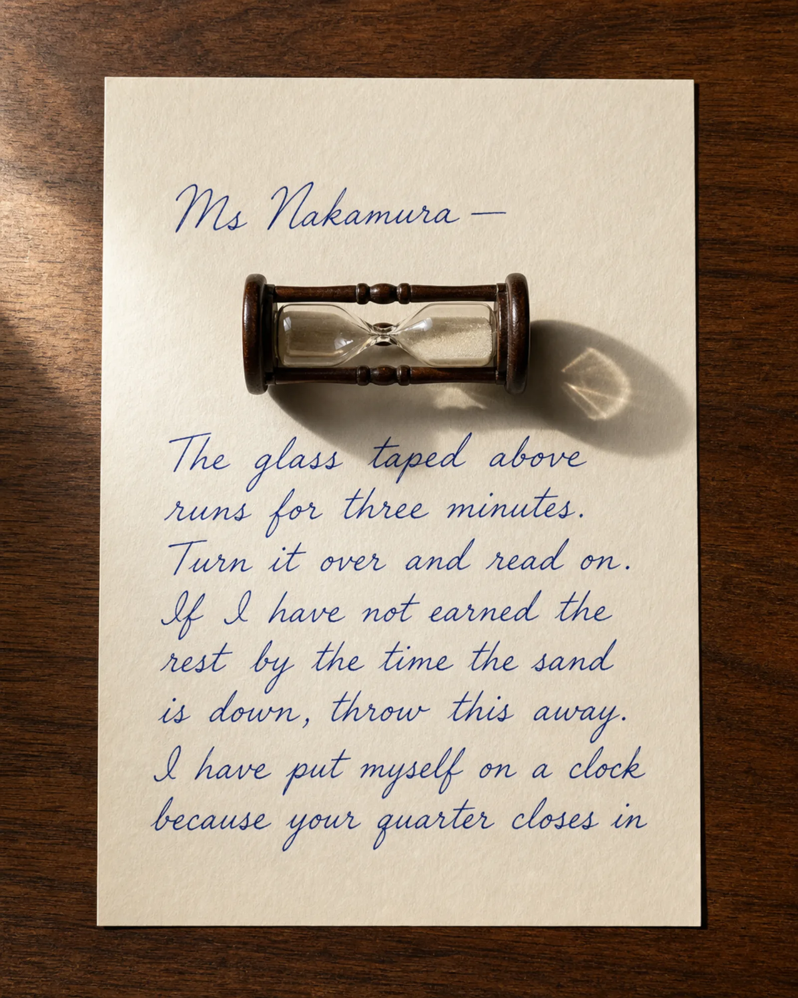 A small hourglass lying across a handwritten letter.